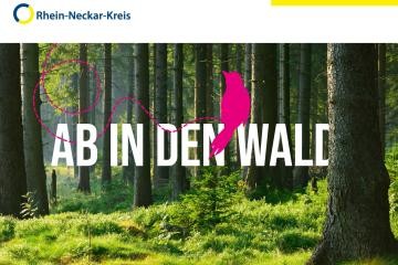 Waldansicht mit Schriftzug "Ab in den Wald"