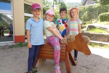 4 Kinder mit Holzpferd im Garten der Kita Wiesenbacher Tal